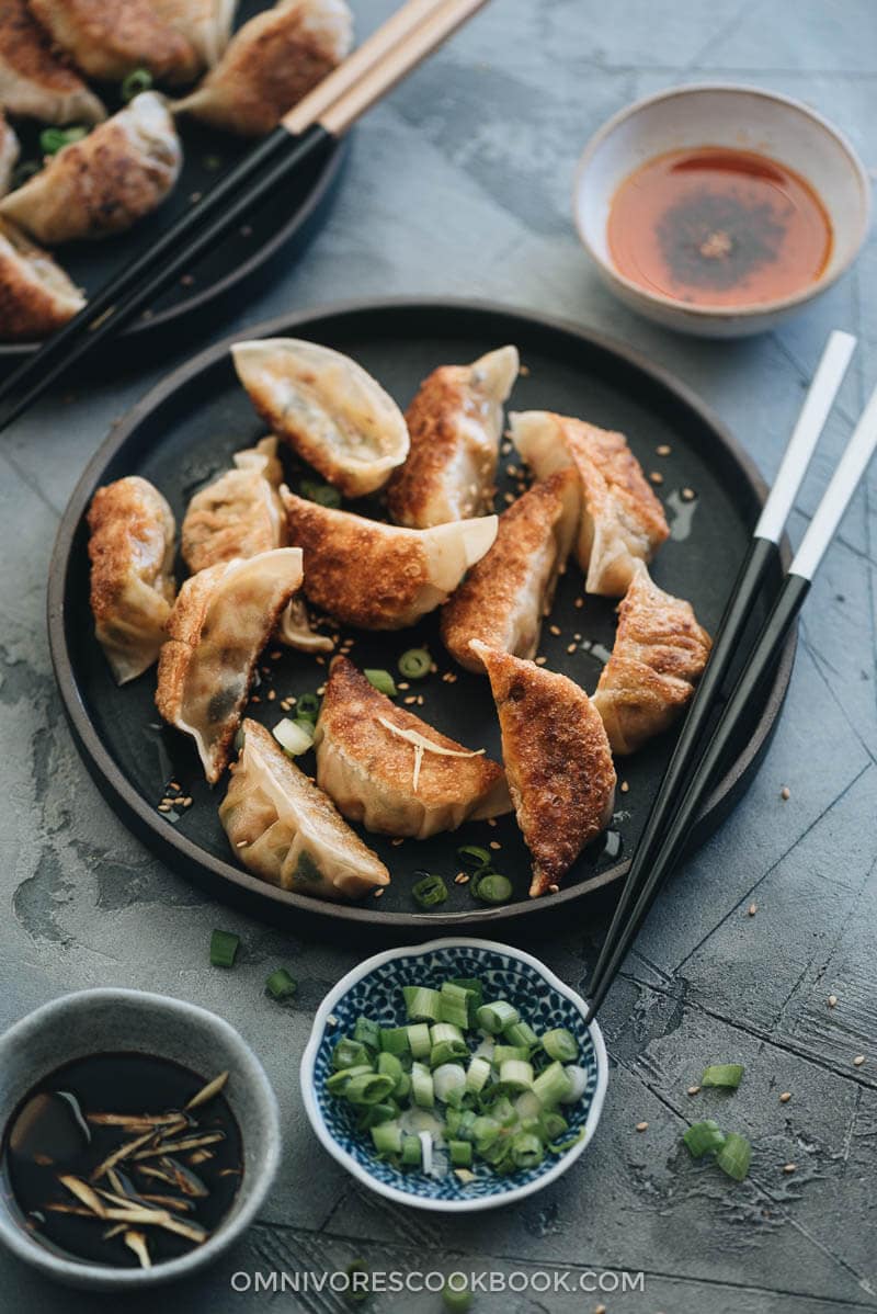 Homemade Vegan Dumplings - The dumpling filling has a well-balanced texture with veggies, tofu, and rice vermicelli. It’s seasoned with plenty of aromatics, soy sauce, and just a dash of curry powder to enhance its richness. #chinese #vegetarian Cooked vegetable dumplings served with dipping sauce