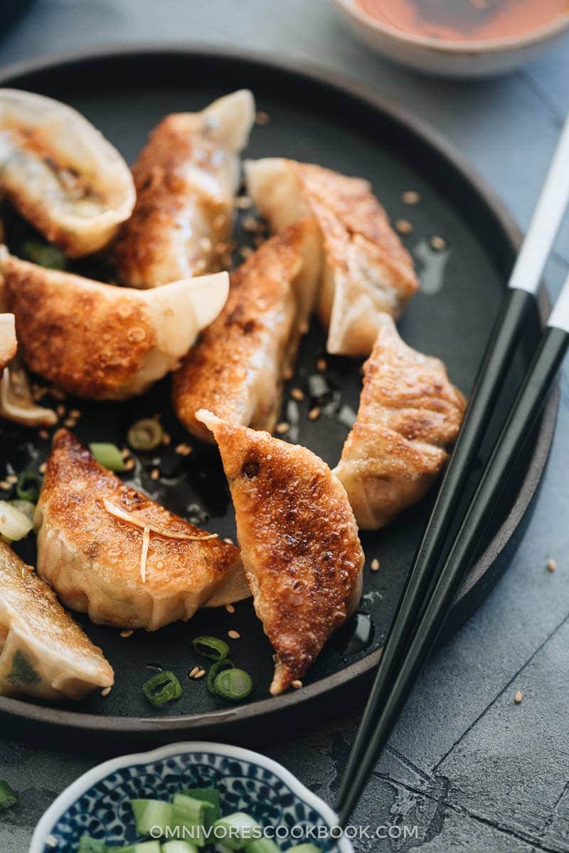 Homemade Vegan Dumplings - The dumpling filling has a well-balanced texture with veggies, tofu, and rice vermicelli. It’s seasoned with plenty of aromatics, soy sauce, and just a dash of curry powder to enhance its richness. #chinese #vegetarian Cooked vegetarian dumplings close up