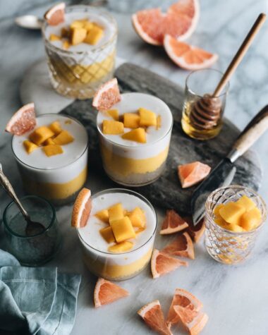 Four cups of mango sago served with grapefruits as a garnish