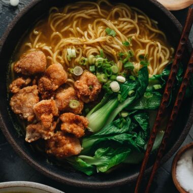 Chinese noodle soup topped with crispy chicken and baby bok choy