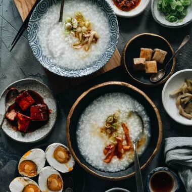 Plain congee topped with pickles, sesame oil and green onion