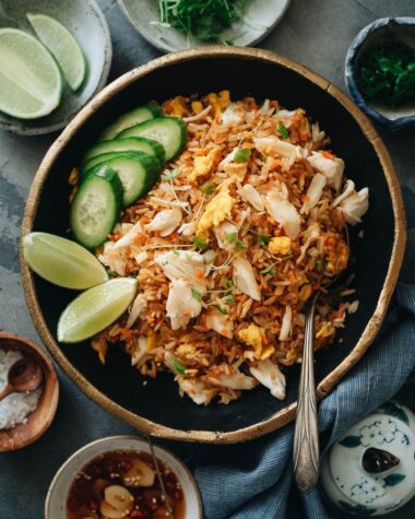 Crab fried rice with lime wedges and cucumber