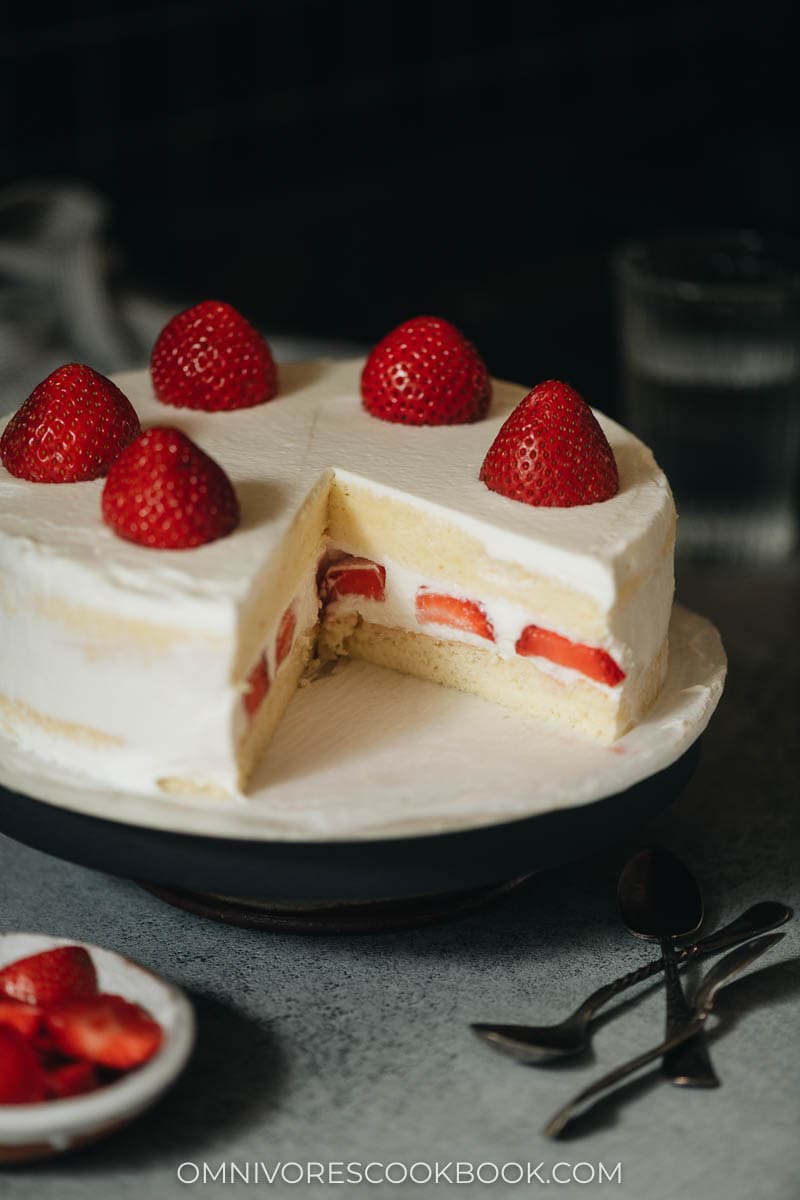 A cake on a platter with one piece missing