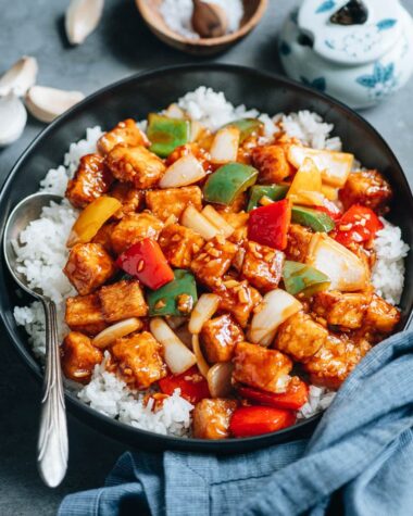 Sweet and sour tofu with pepper and onion over steamed rice