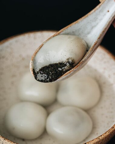 Black sesame tang yuan close up with filling oozing out