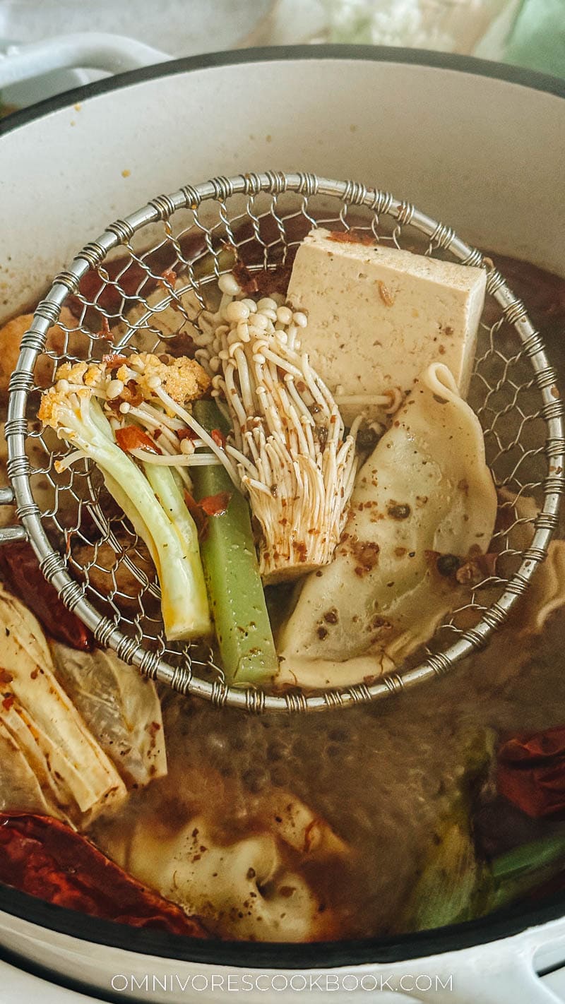 Taking vegetables out of hot pot both