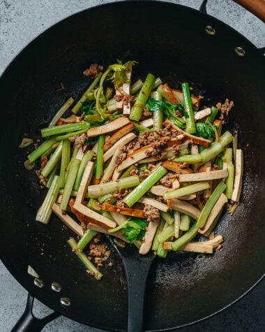 Dried tofu and celery stir fry in a wok