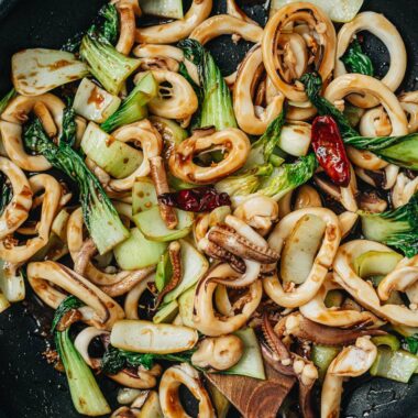 Squid and bok choy stir fry in a pan close up