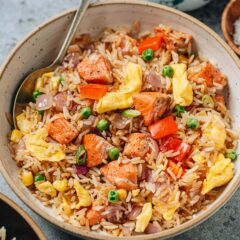 Salmon fried rice is a delicious one-pan meal that you can quickly whip together using a few pantry ingredients. The juicy salmon, tender eggs, crisp veggies and buttery rice all work together to create a satisfying and healthy meal for your weekday dinner. {Gluten-Free Adaptable}