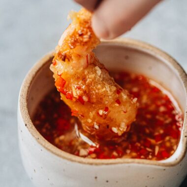 Dipping coconut shrimp into dipping sauce