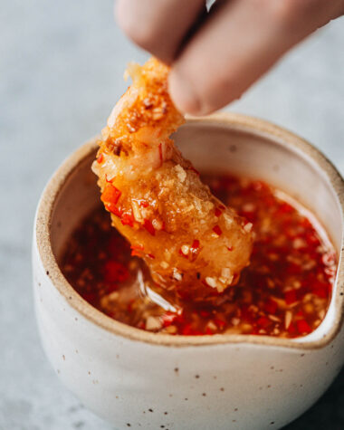 Dipping coconut shrimp into dipping sauce
