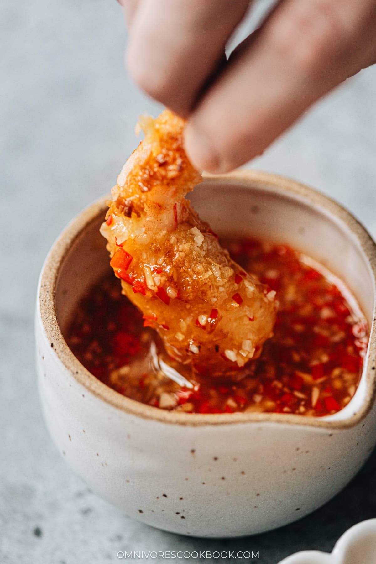 Dipping coconut shrimp into dipping sauce