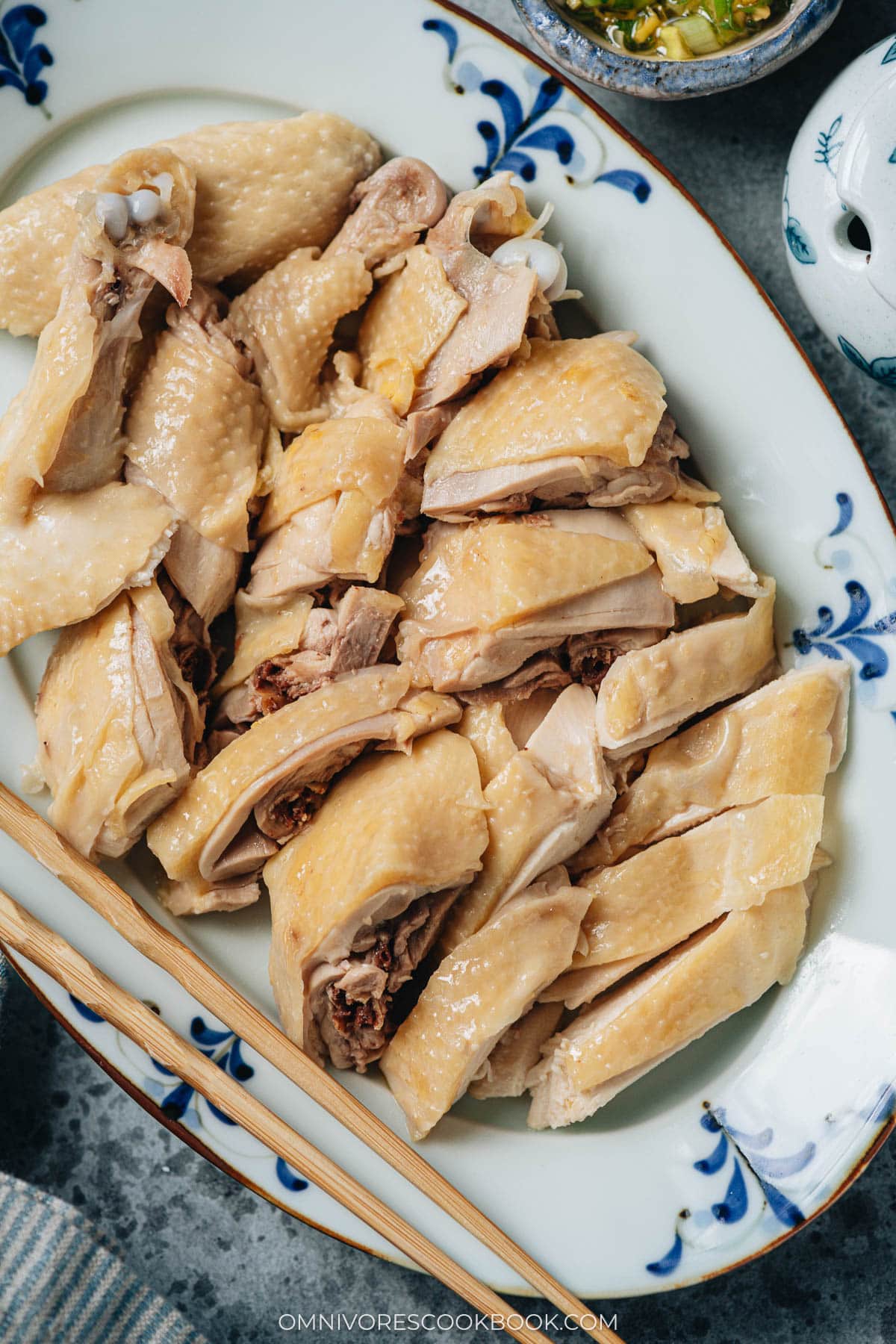 Carved white cut chicken served in a plate close up